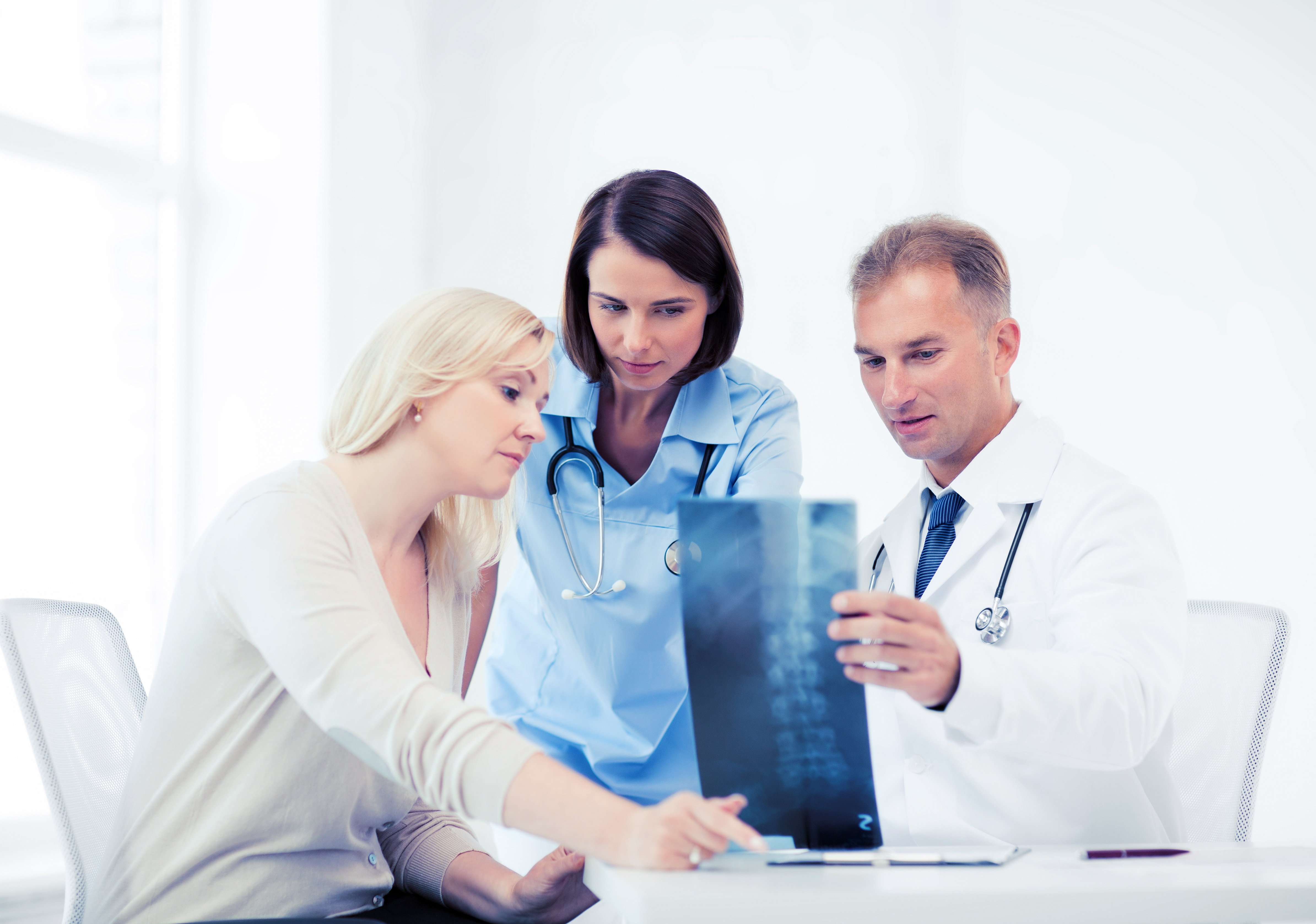 Orthopaedic care team reviewing X-ray imaging together, illustrating multidisciplinary collaboration and patient-centred care excellence