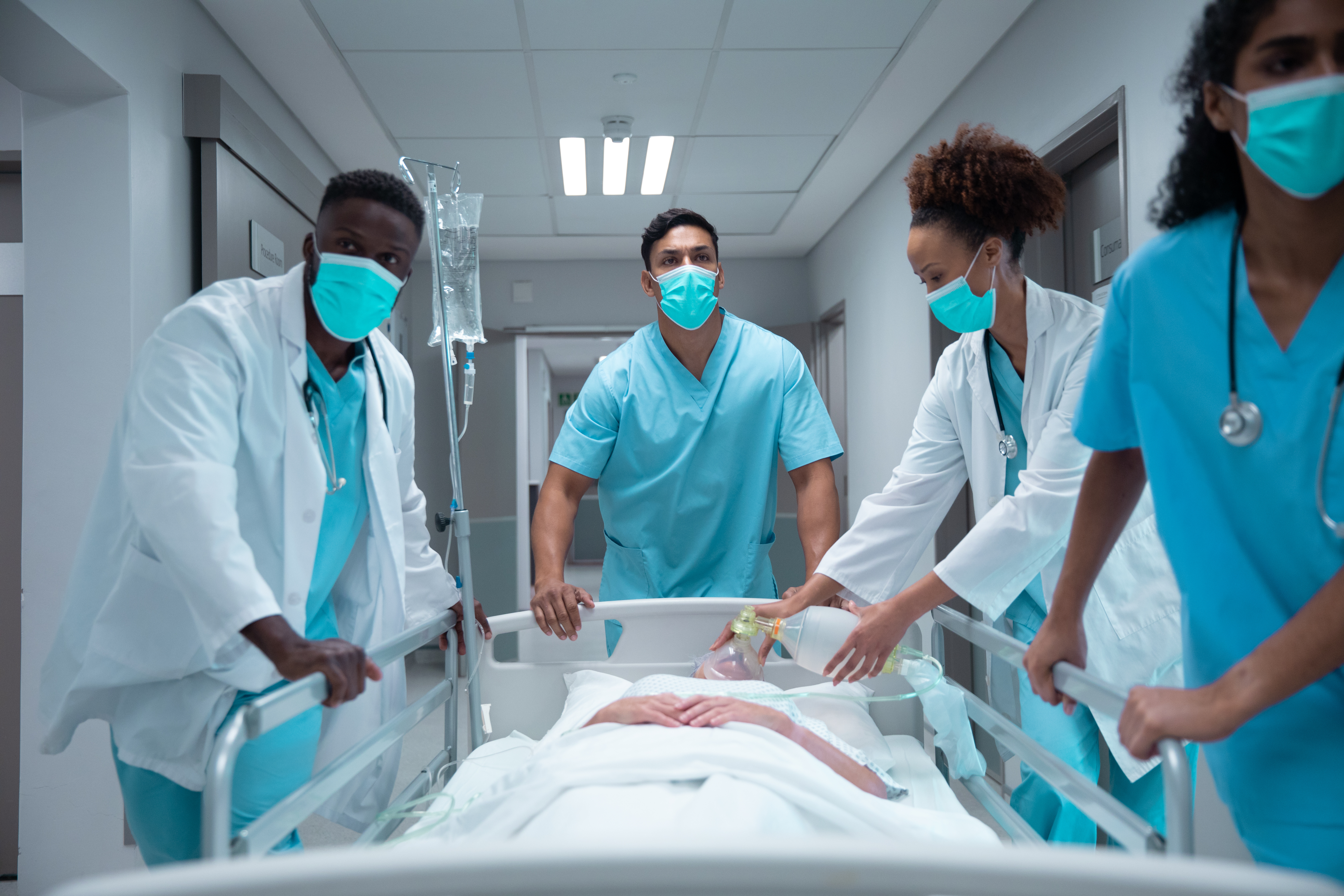 Clinical team in protective equipment preparing a patient for transport, demonstrating safe, standardized infection prevention practices aligned with DNV’s Certification in Infection Prevention